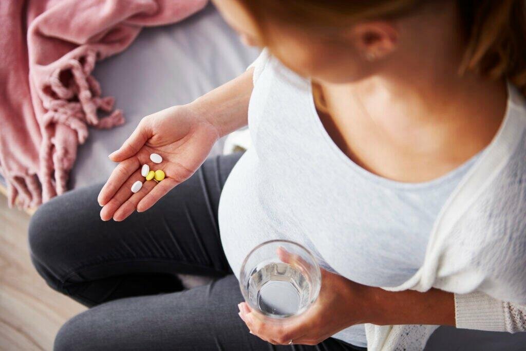 young pregnant woman taking medicine